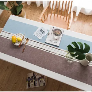 Dettaglio del runner in lino blu e caffè con ricamo geometrico in pizzo bianco traforato