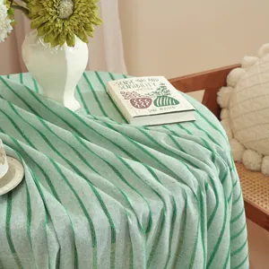 Detail of green striped cotton linen tablecloth with soft texture and natural drape