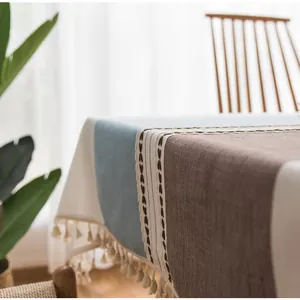 Dettaglio ricamo a cuore e nappe beige sulla tovaglia in misto cotone e lino