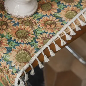 Detailopname van tafelloper met zonnebloemprint, witte franjes en geweven textuur