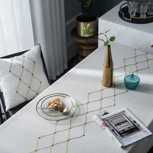 Detailopname van Noords linnen tafelkleed met gouden geometrische borduring
