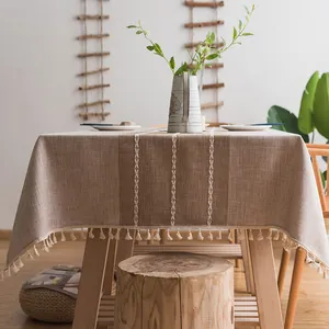 Dettaglio della tovaglia in lino con ricami bianchi e nappe decorative sui bordi