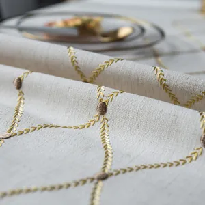 Detailopname van geometrisch borduurwerk en linnen textuur op een Noords tafelkleed