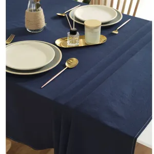 Detail of dark blue cotton tablecloth showing white stitching and textile texture