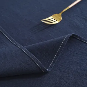 Close-up of navy blue cotton tablecloth featuring elegant white contrast stitching edges