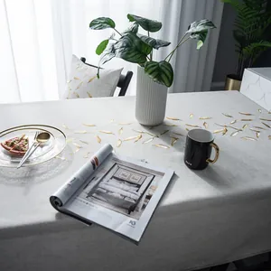 Detail van het beige linnen tafelkleed met elegante goudfolie vederborduring erop