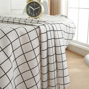 Close-up of black and white windowpane plaid cotton linen tablecloth with vintage clock