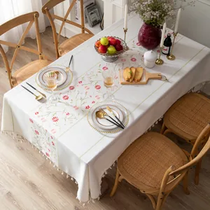 Detail of floral embroidery and woven tassels on a high-quality cotton linen tablecloth