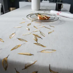 Detailweergave van gouden bladborduurwerk op een lichtgrijs linnenmix tafelkleed