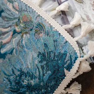 Gedetailleerde macro-opname van geweven wandtapijt met blauw kunstpatroon en witte kwastjes