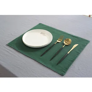 Détail du set de table en lin vert foncé avec couture blanche pour décoration de table