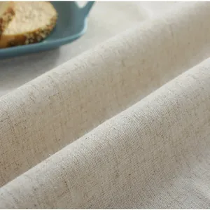 Detailopname van vintage beige katoenen tafelkleed met ruches en natuurlijke weeftextuur