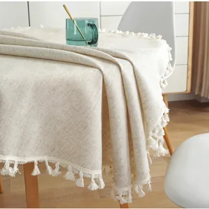 Nappe minimaliste en lin crème avec bordures à franges sur une table en bois