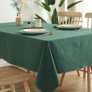 Close-up of dark green solid color cotton tablecloth with white stitched edges and fabric texture