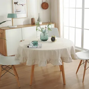 Detailed view of beige linen-blend round tablecloth featuring elegant ruffled edge draping