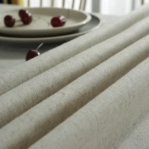 Close-up of beige linen tablecloth fabric texture with rustic weave and cherry accents