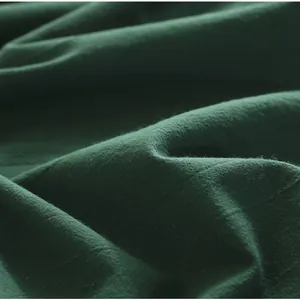 Detailed macro view of pure green cotton tablecloth fabric showing woven texture