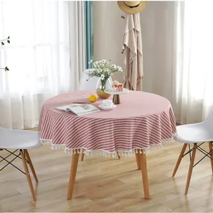 Close-up of a red and white striped round tablecloth with white tassel trim