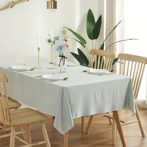 Minimalist sage green cotton tablecloth with linen texture on a rectangular dining table