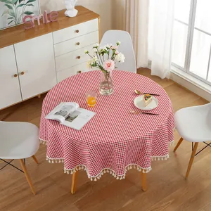 Detail of red and white checkered round tablecloth featuring elegant white tassel fringe edges