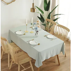 Detailed texture of light green cotton linen tablecloth with natural drape and soft wrinkles