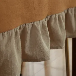 Detail van vintage katoenen tafelkleed met oranjebruine stiksels en beige ruisrand