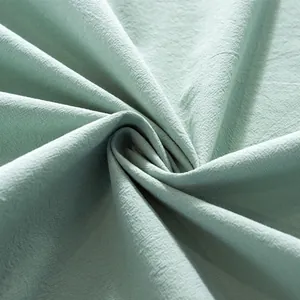 Detail of mint green cotton linen tablecloth with natural slub texture and soft folds