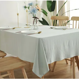 Detail of light green rectangular cotton tablecloth with neat edge stitching and soft drape
