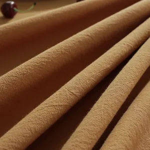 Macro detail van karamelkleurig gewassen katoenen tafelkleed met natuurlijke textuur