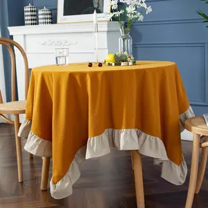 Detailed close-up of retro mustard yellow round tablecloth with beige ruffled lotus edges