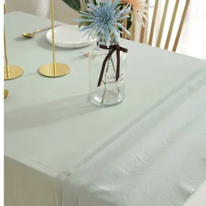 Detailed texture of sage green cotton tablecloth with natural wrinkles and neat stitching
