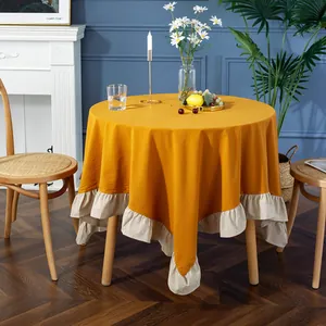 Detailed close-up of mustard yellow tablecloth featuring elegant beige ruffled edges