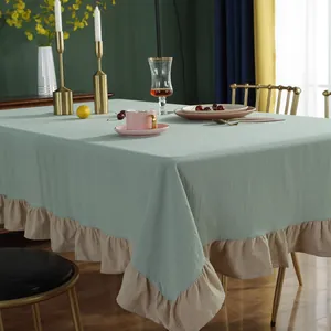 Detail van een mintgroen katoenen tafelkleed met een crème ruche rand in retro stijl
