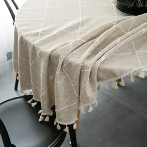 Beige round tablecloth with white grid embroidery and decorative tassels for dining room