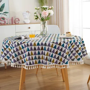 Detail of round cotton linen tablecloth featuring Nordic geometric patterns and white tassels