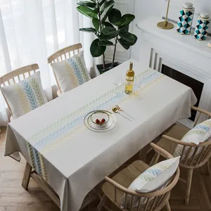 Noords linnen tafelkleed met geometrisch bladborduursel en bijpassende kussens op houten tafel