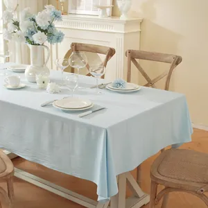 Detail view of light blue cotton tablecloth featuring delicate fabric texture and drape