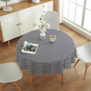 Detail of round cotton linen tablecloth with blue and white wave pattern draping elegantly