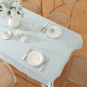 Close-up of light blue cotton tablecloth featuring a natural woven texture and table setting