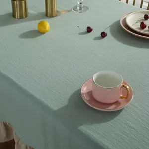Detail van saliegroen tafelkleed van gewassen katoen met beige ruches aan de rand