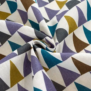 Close-up of geometric printed tablecloth fabric with thick linen texture and tassel fringe
