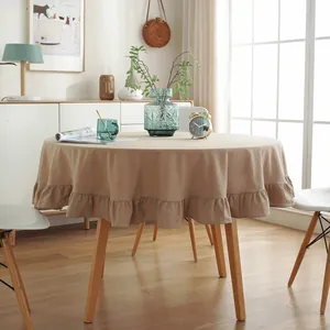Detail of round linen tablecloth with ruffled edges in a cozy home setting