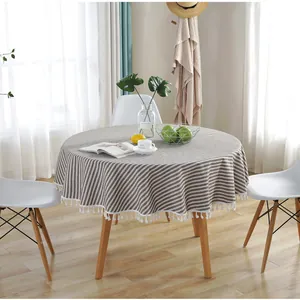 Detailed close-up of a brown and white striped round tablecloth with elegant white tassels