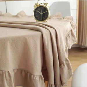 Detailed close-up of khaki ruffles on a vintage cotton linen tablecloth with retro clock