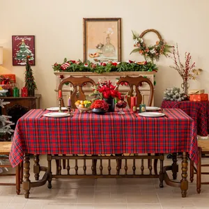 Detail van rood geruit kersttafelkleed met zware stof gedrapeerd op een rechthoekige tafel