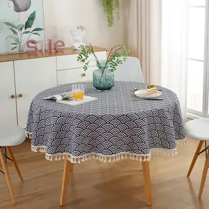 Detailed close-up of a round tablecloth with blue wave pattern and white tassel fringe