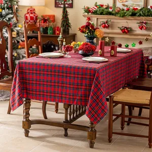 Klassiek rood geruit kersttafelkleed op een feestelijke tafel met decoratie en warme lichten