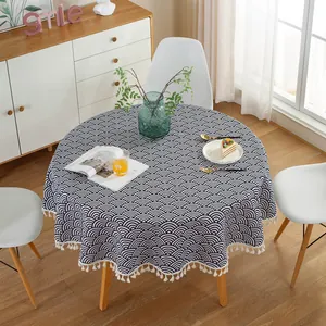 Detailed view of round tablecloth with blue wave pattern and white fringe tassel edges