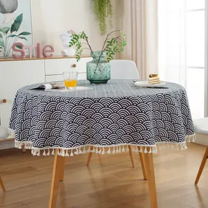 Detail of round cotton linen tablecloth with blue wave pattern and white fringe edge