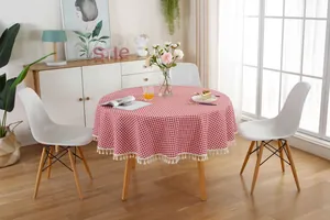Close-up of red and white gingham round tablecloth with delicate white cotton tassels